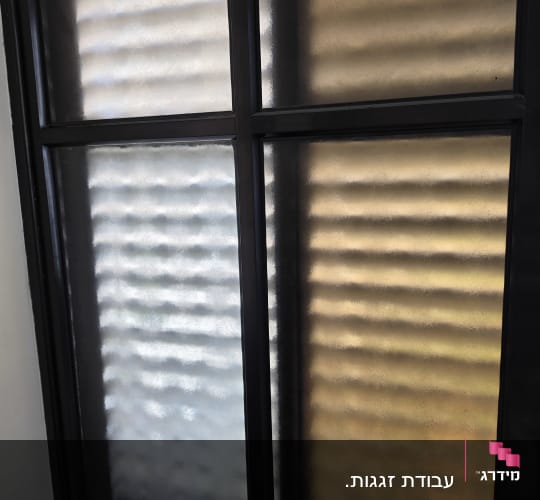 חלון זכוכית עם מסגרת מתכת כהה
